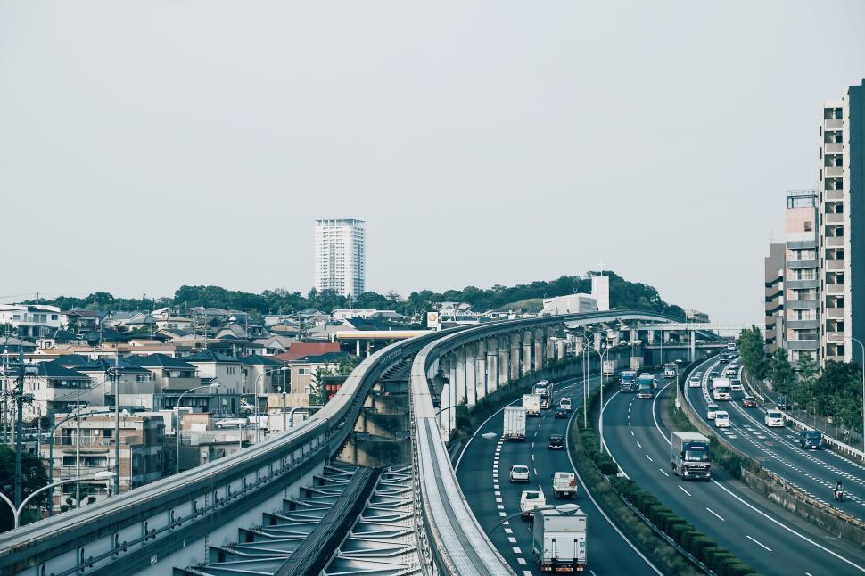 Free Image of Urban landscape with highway and residential buildings, sunny day. 