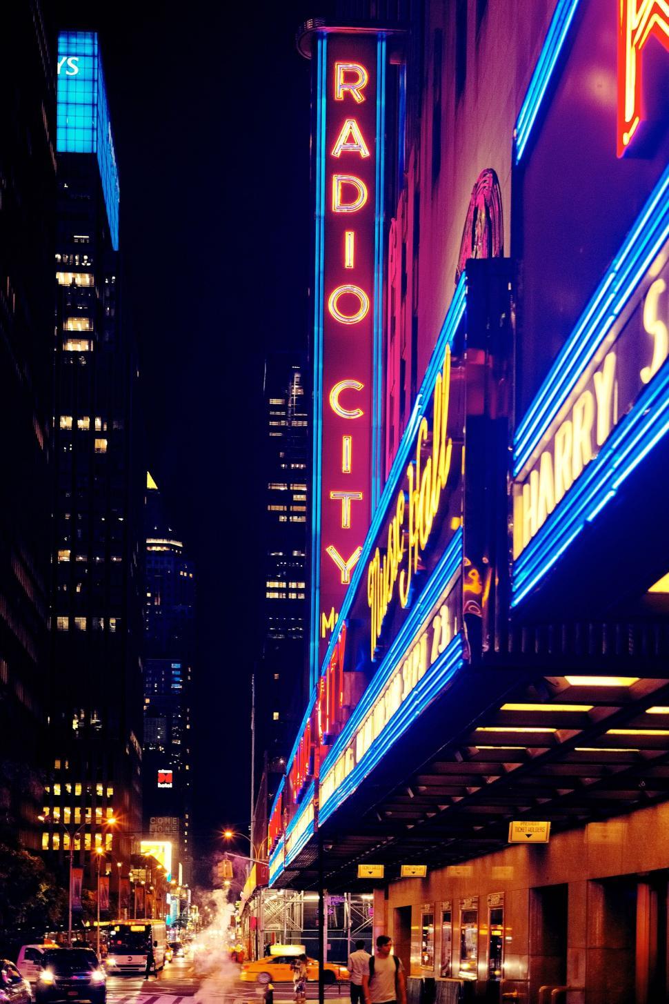 Free Image of Neon lights of Radio City at night in a bustling urban street 