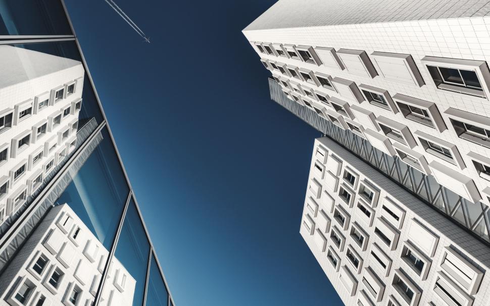 Free Image of Skyscrapers and reflections under a clear sky viewed from below 