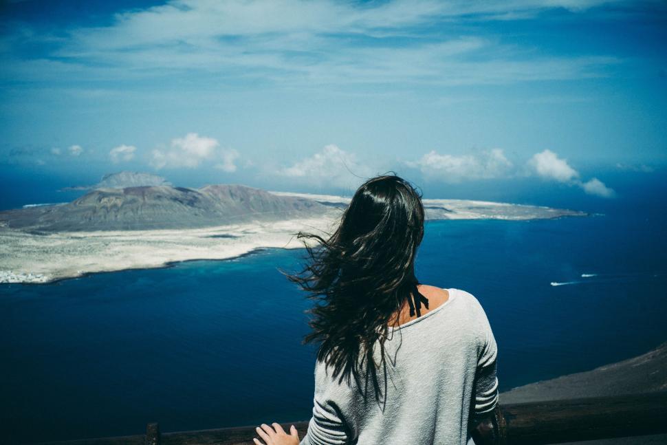 Free Image of Woman gazing at vast ocean view under a clear blue sky 