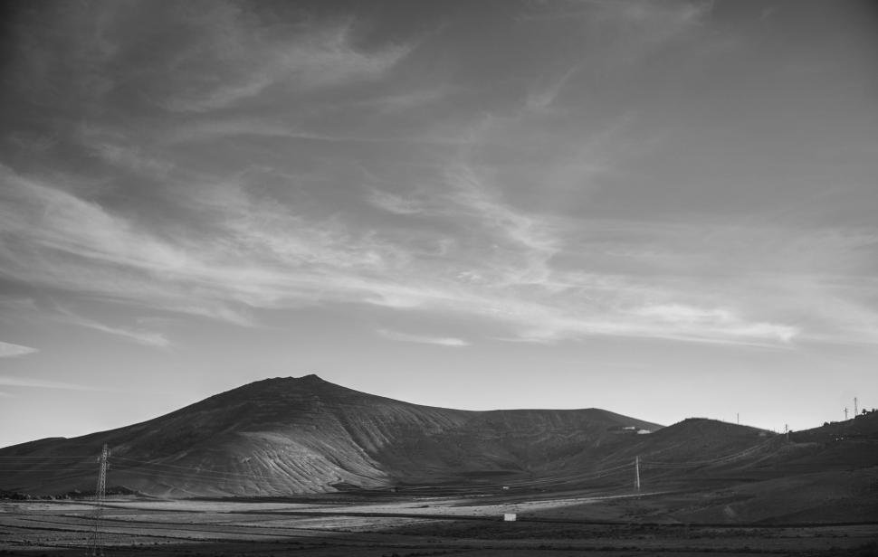 Free Image of Black and white photo depicting a vast empty landscape with hills 