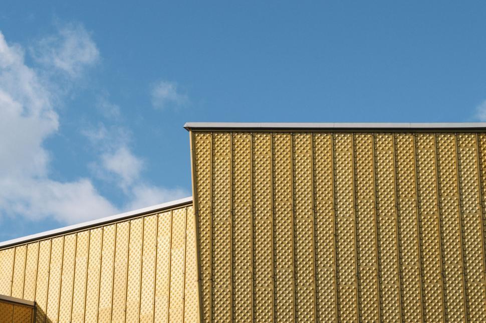 Free Image of Golden yellow modern architecture against a clear blue sky. 