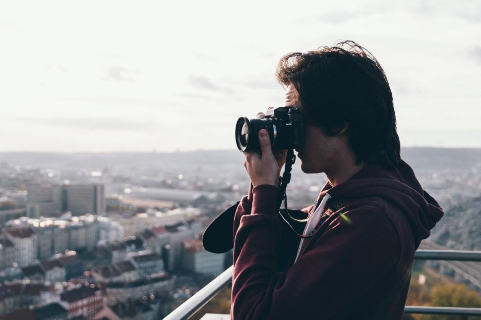Free Image of A person with a camera capturing a city view from a high vantage 