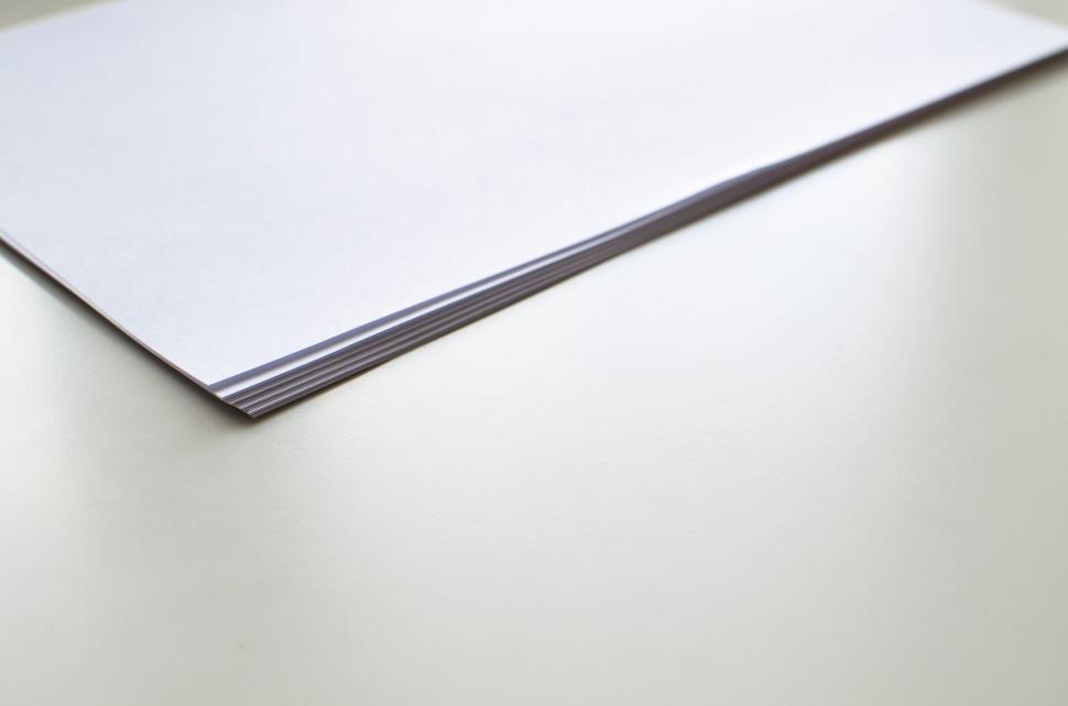 Free Image of Stack of blank white printing paper sheets on a plain white surface 