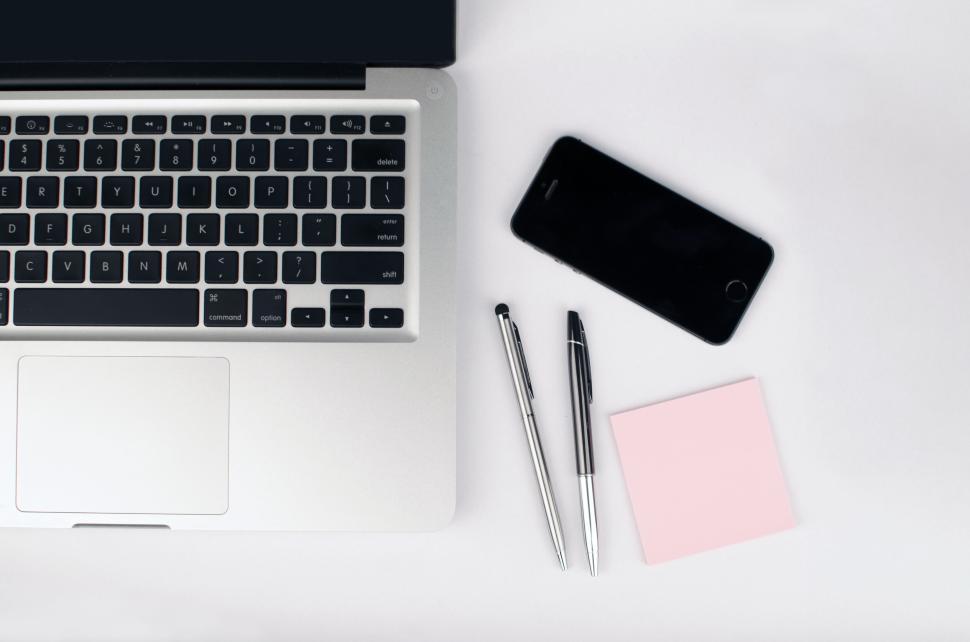 Free Image of Laptop, smartphone, pens, and sticky notes on a white surface 