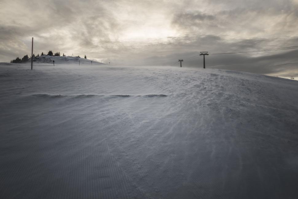 Free Image of Snowy landscape with ski lift in the backdrop at sunset 