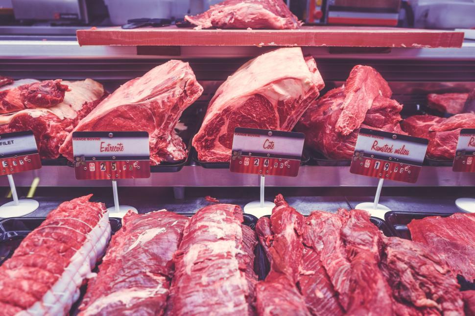 Free Image of Variety of fresh meat cuts displayed in a butcher shop counter rack 