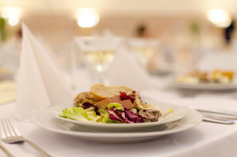 Free Image of Elegant dining table with a plate of gourmet food and wine glass 