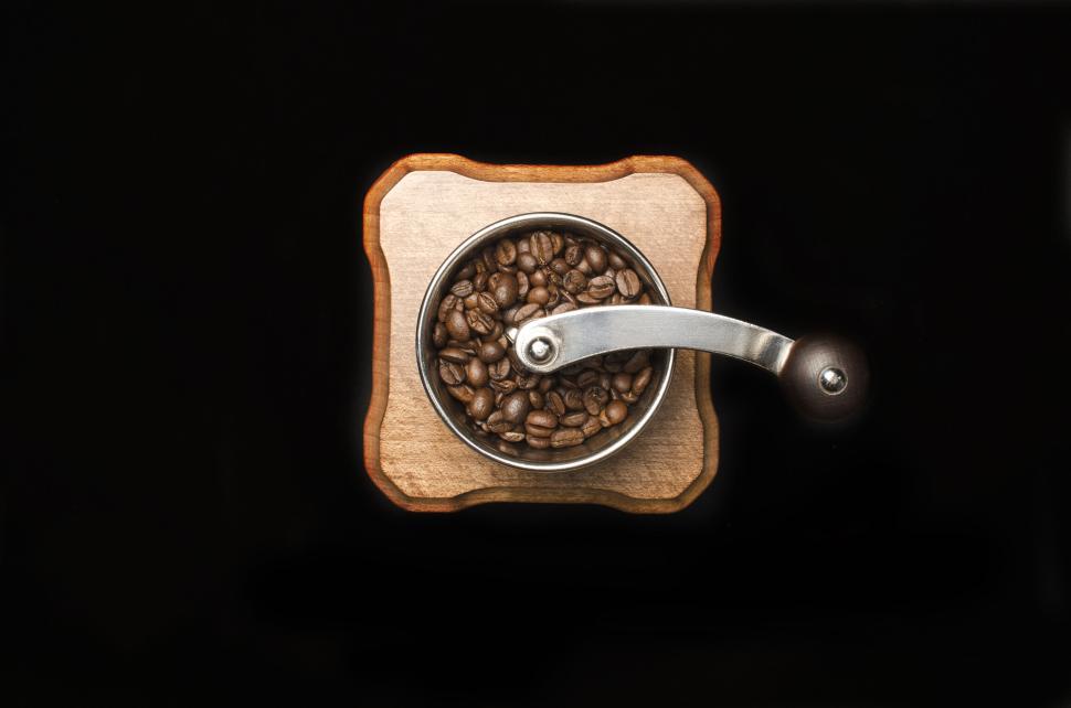 Free Image of Wooden coffee grinder with freshly roasted coffee beans on black background 