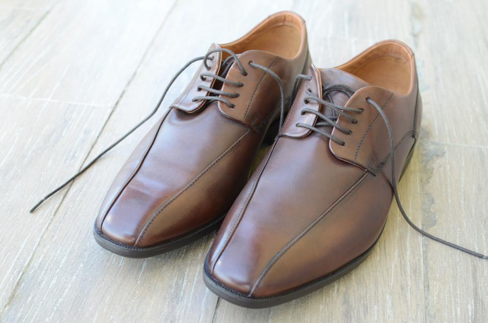 Free Image of Pair of brown leather dress shoes on a light wooden floor. 
