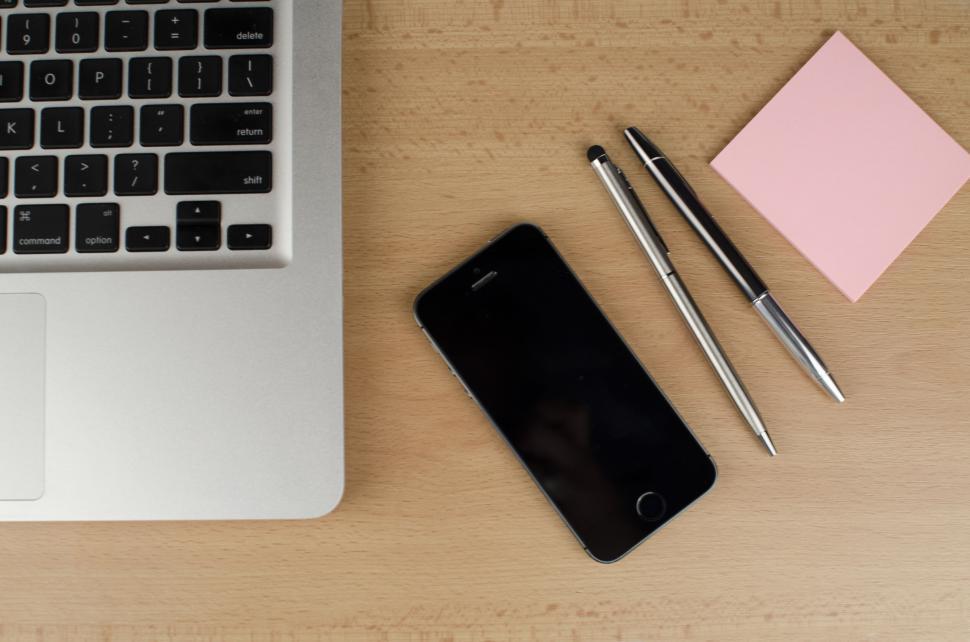 Free Image of Laptop, smartphone, pens, and sticky note on a wooden table 