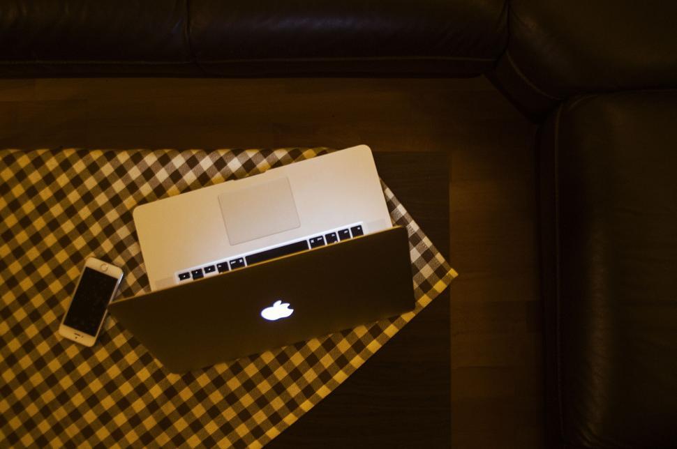 Free Image of Laptop and smartphone on a checkered cloth on a couch 
