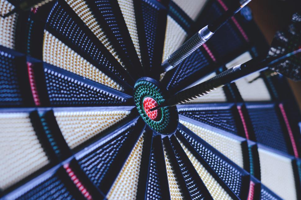 Free Image of A game of darts captured mid-flight hitting the bullseye perfectly 