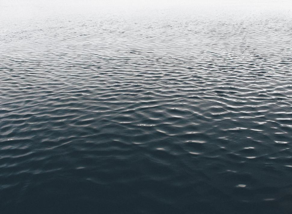 Free Image of Calm water body with gentle ripples under soft ambient light. 