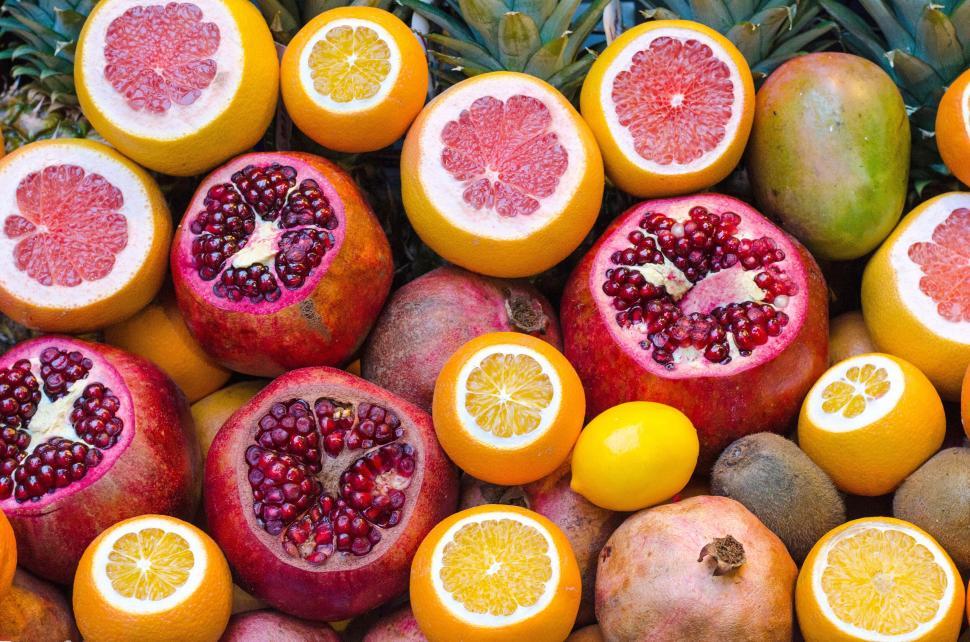 Free Image of A variety of fresh citrus fruits and pomegranates piled together beautifully. 