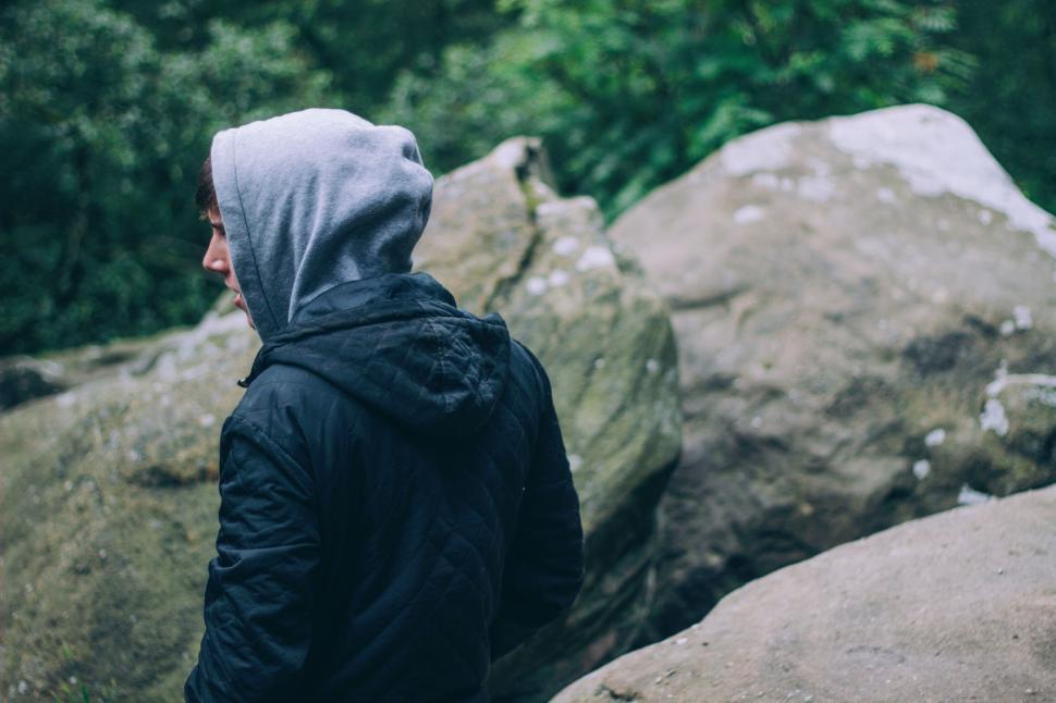 Free Image of Person exploring a rocky area wearing a hoodie and a jacket 