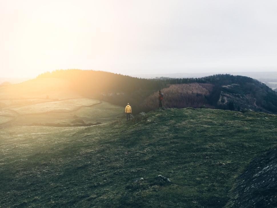 Free Image of Two hikers in the distance enjoying a misty mountain top sunrise. 