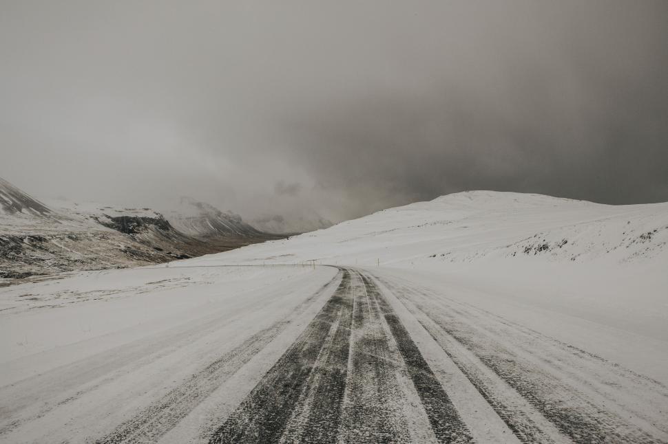 Free Image of Snowy road stretching through a barren winter landscape 