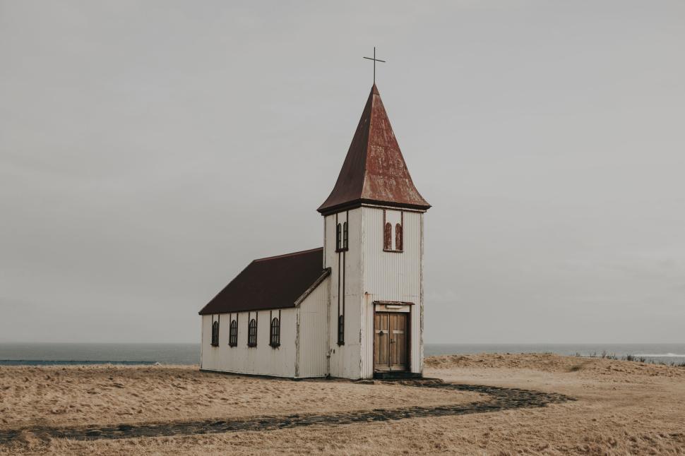 Free Image of Rustic old chapel with a steeple standing in an empty field 