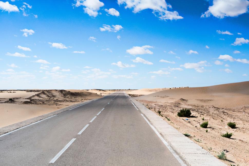 Free Image of Deserted road stretches into desert under clear blue sky 