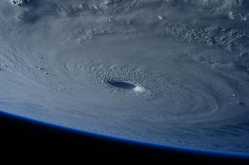 Free Image of A giant storm system with a clearly defined eye viewed from space. 