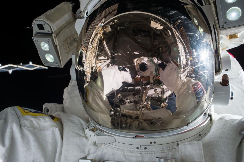 Free Image of Astronaut with a helmet reflecting the space station around it. 