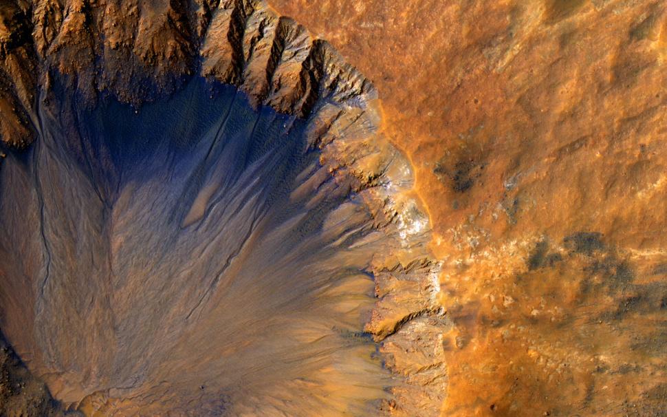 Free Image of A vibrant, aerial view of a Martian landscape with large crater. 