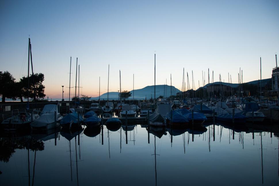 Free Image of Serene marina at dusk with boats silhouetted against the twilight sky 