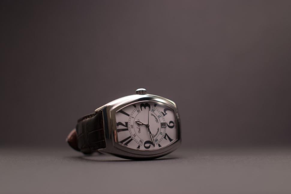 Free Image of Elegant wristwatch with leather strap placed against a dark backdrop. 