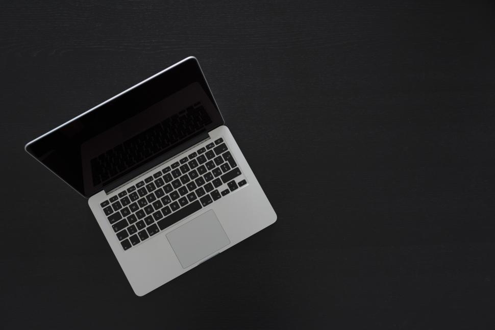 Free Image of Open laptop on black surface with a minimalistic and clean design. 