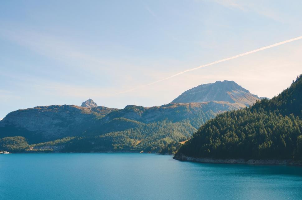 Free Image of Scenic lake view with mountains under a clear blue sky background. 