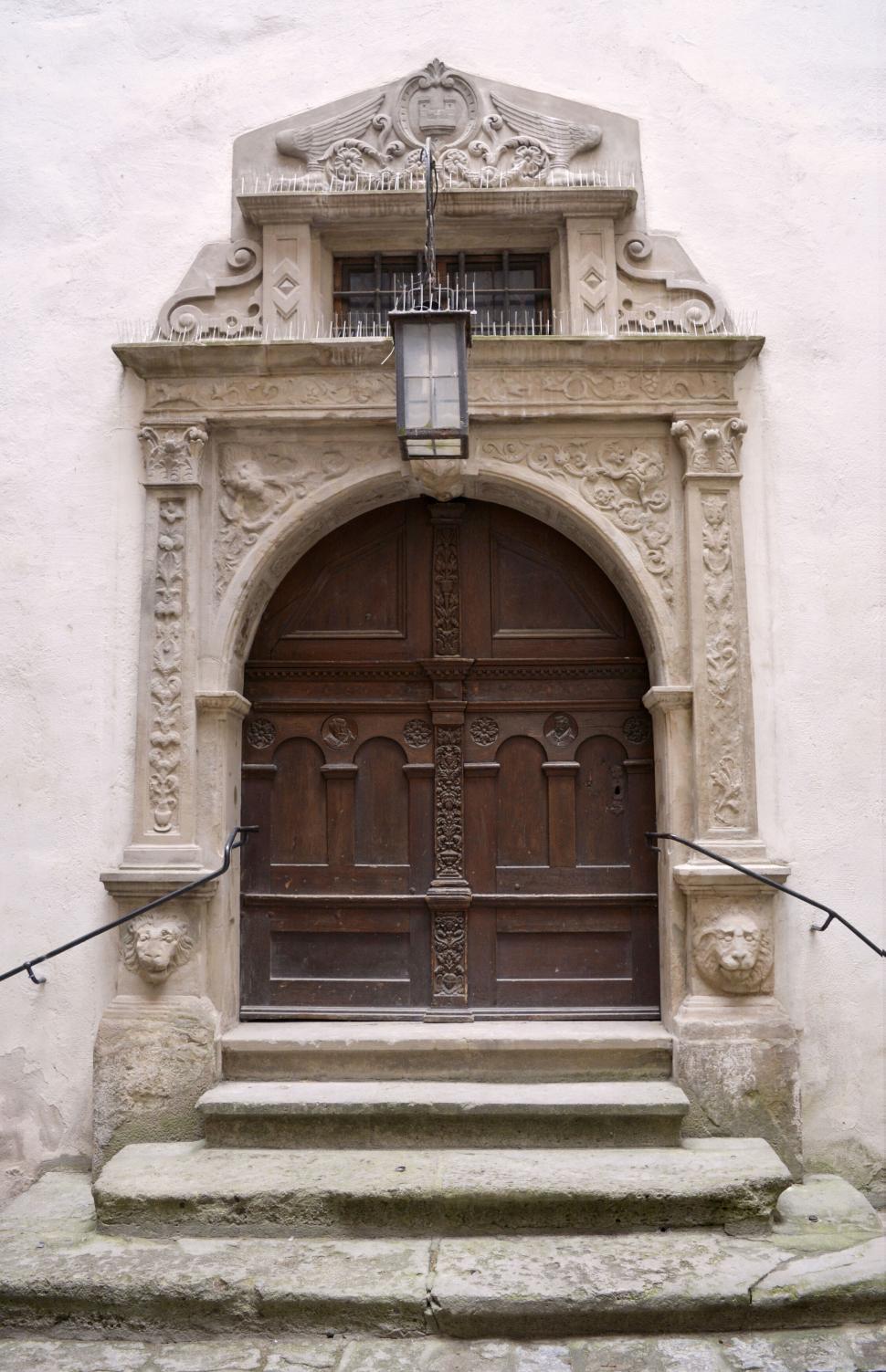 Free Image of Ornate old wooden door surrounded by intricate carved stonework. 
