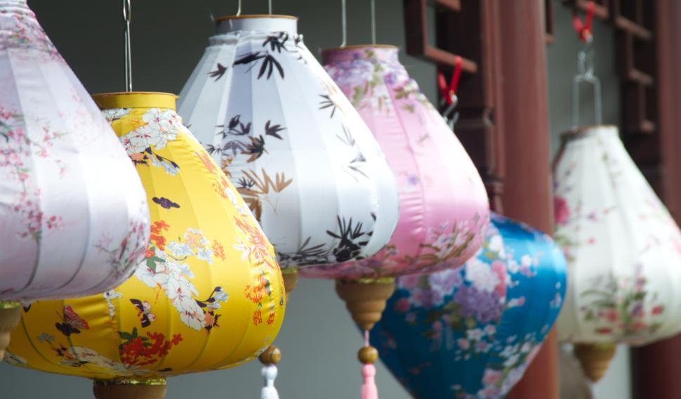 Free Image of Colorful traditional lanterns hanging outdoors in a row 