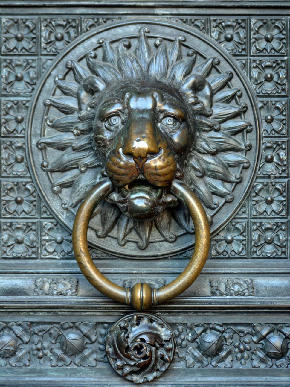 Free Image of Ornate door knocker with lion head on decorative metal door 