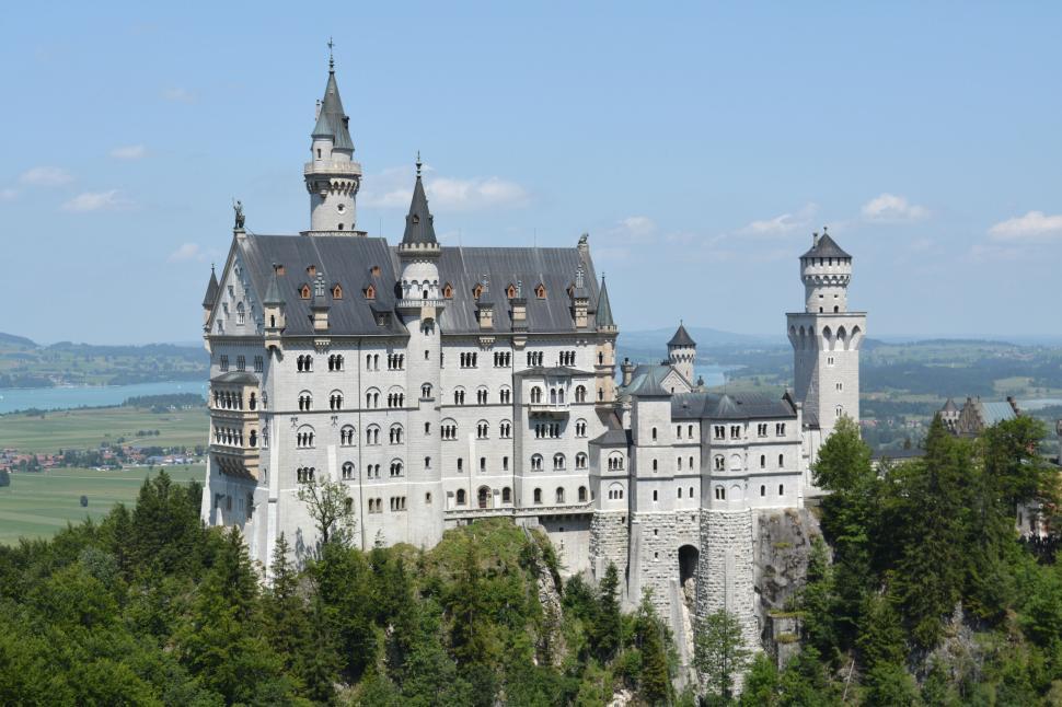 Free Image of Majestic hilltop castle surrounded by a lush green forest 