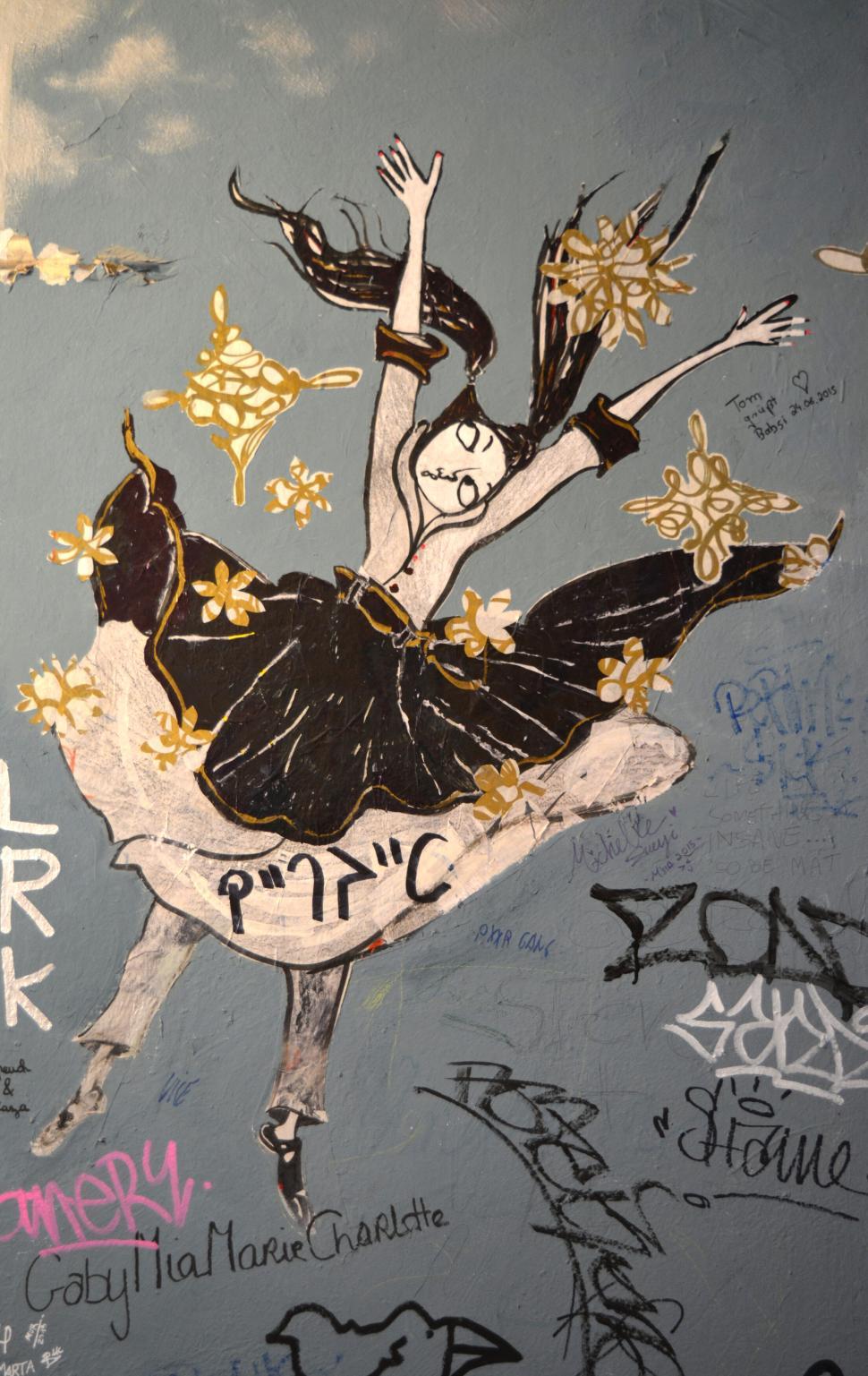 Free Image of Street art graffiti of a whimsical dancing figure on a painted wall 