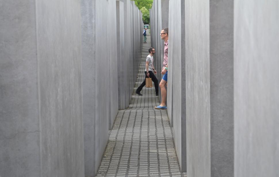 Free Image of People exploring modern outdoor monument with tall concrete slabs. 