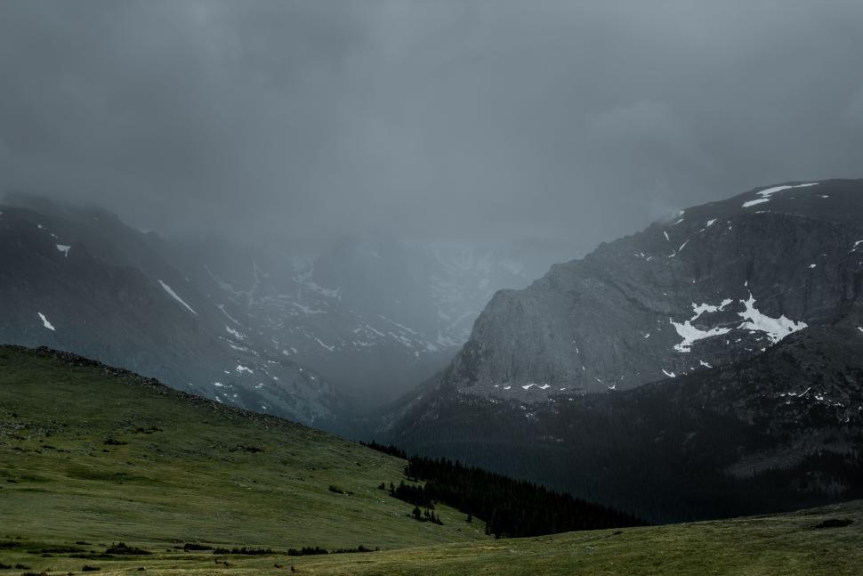 Free Image of Misty valley with rugged mountain range backdrop. 