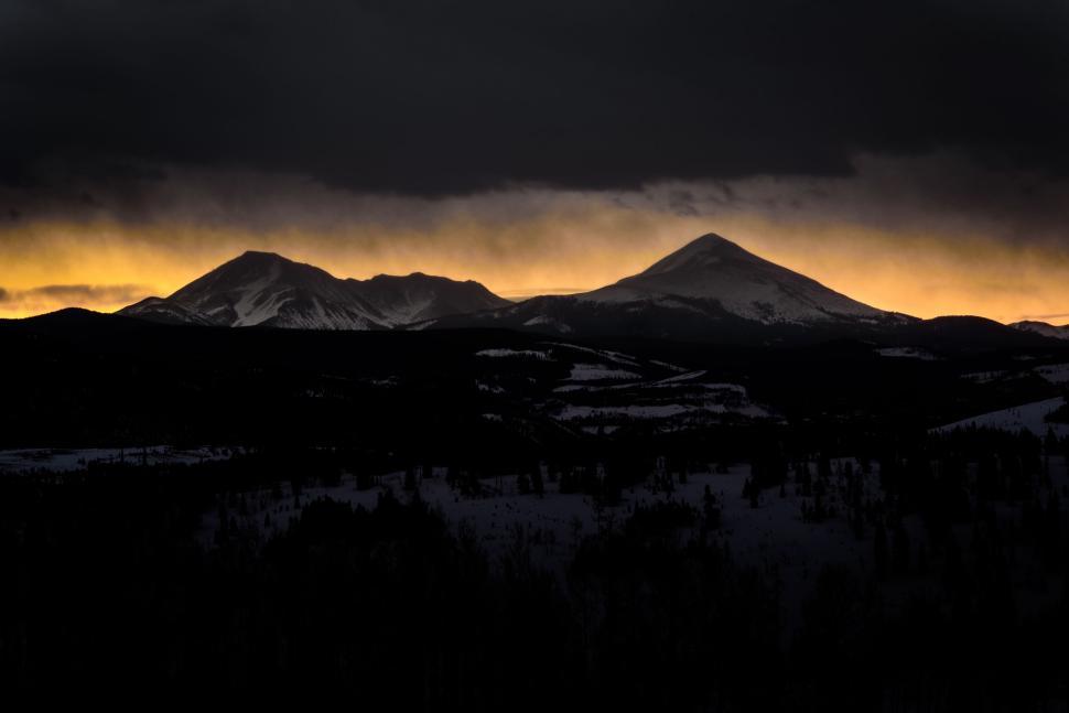 Free Image of Dark mountain silhouettes at sunset with orange sky 