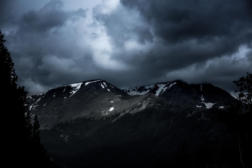 Free Image of Stormy clouds over snow-capped mountain range 