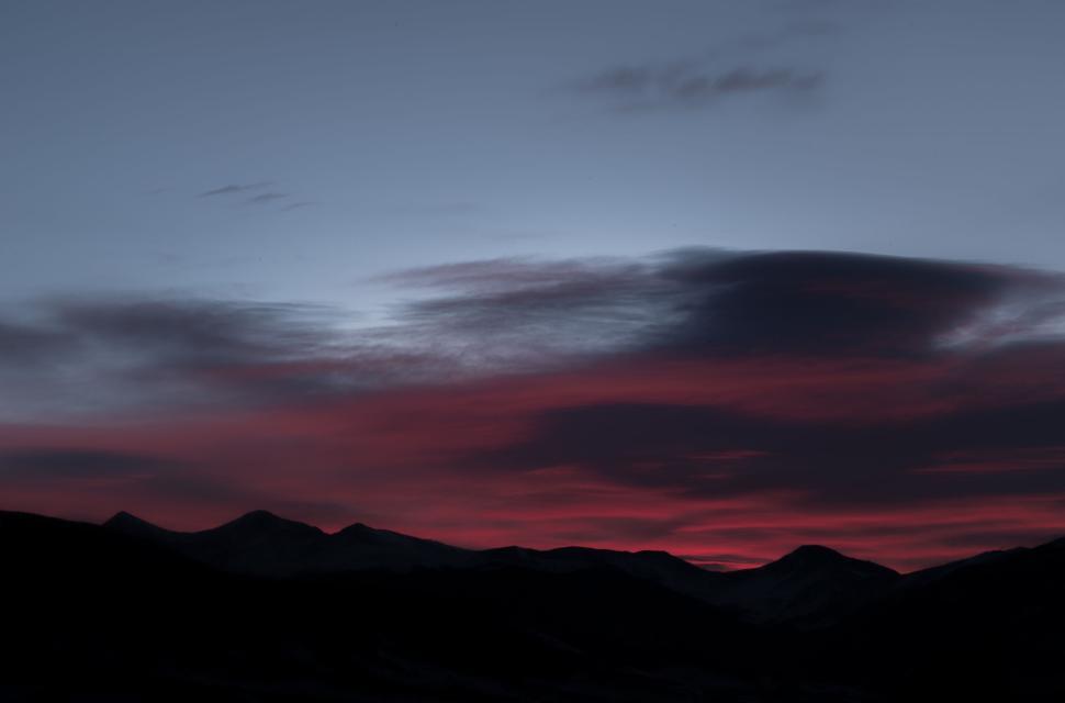 Free Image of Dark silhouette of mountain range against red sunset 