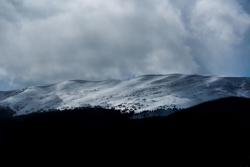 Free Image of Clouds over snow-covered gentle mountain slopes 
