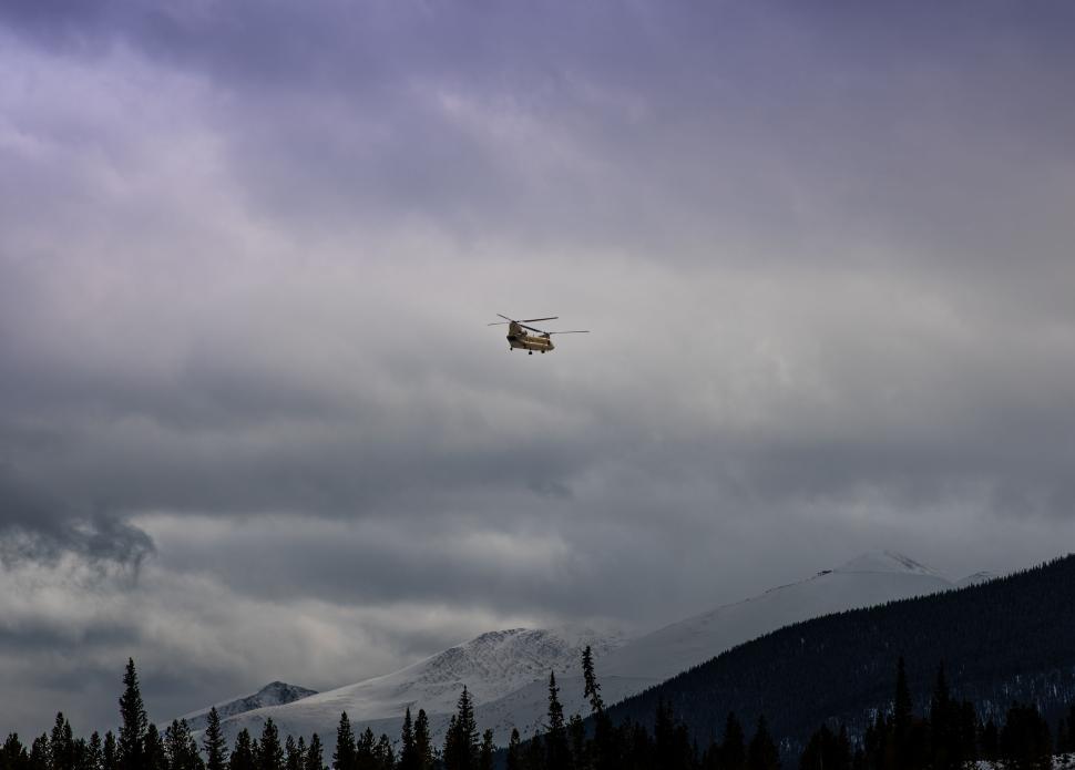 Free Image of Helicopter in flight over snowy mountain range 
