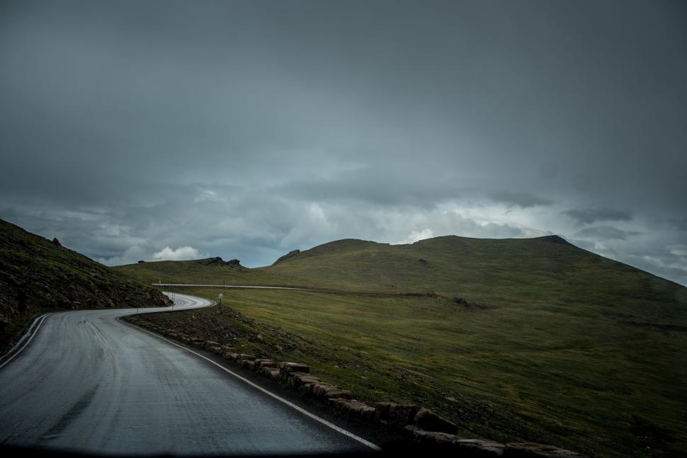 Free Image of Curvy mountain road winding through open landscape 