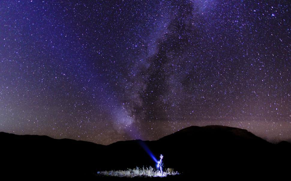 Free Image of Starry night with Milky Way and person with flashlight. 