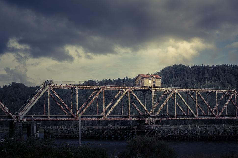 Free Image of Industrial bridge with house over a river during twilight 