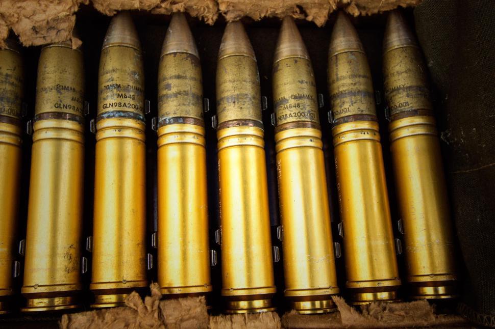 Free Image of Row of golden bullet shells in a wooden box arranged side by side 