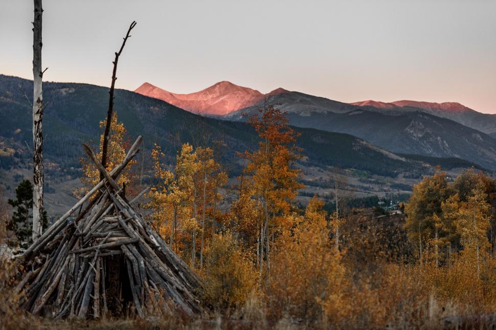 Free Image of Rustic Wooden Teepee in Mountain Landscape at Dusk 