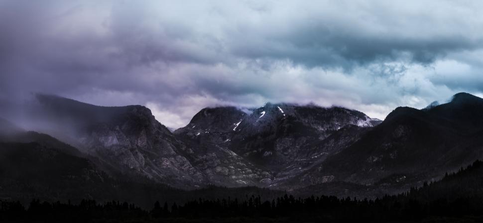 Free Image of Misty mountain range under dramatic, moody sky. 