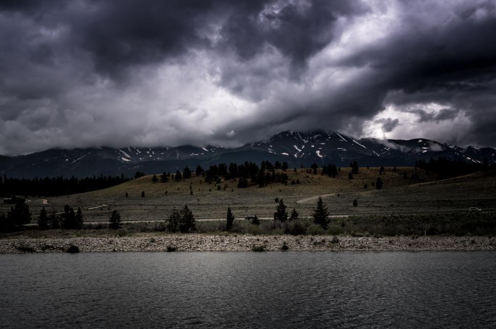 Free Image of Clouded mountain range over a lake during a moody storm 